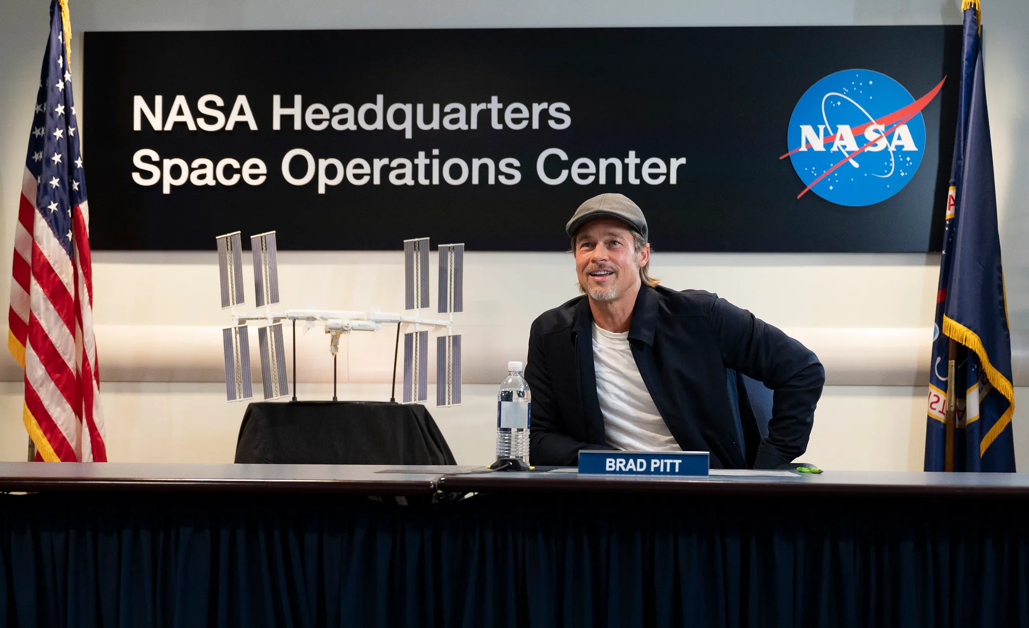 Brad Pitt at NASA Headquarters in 2019, wearing a flat cap that obscures most of his haircut.