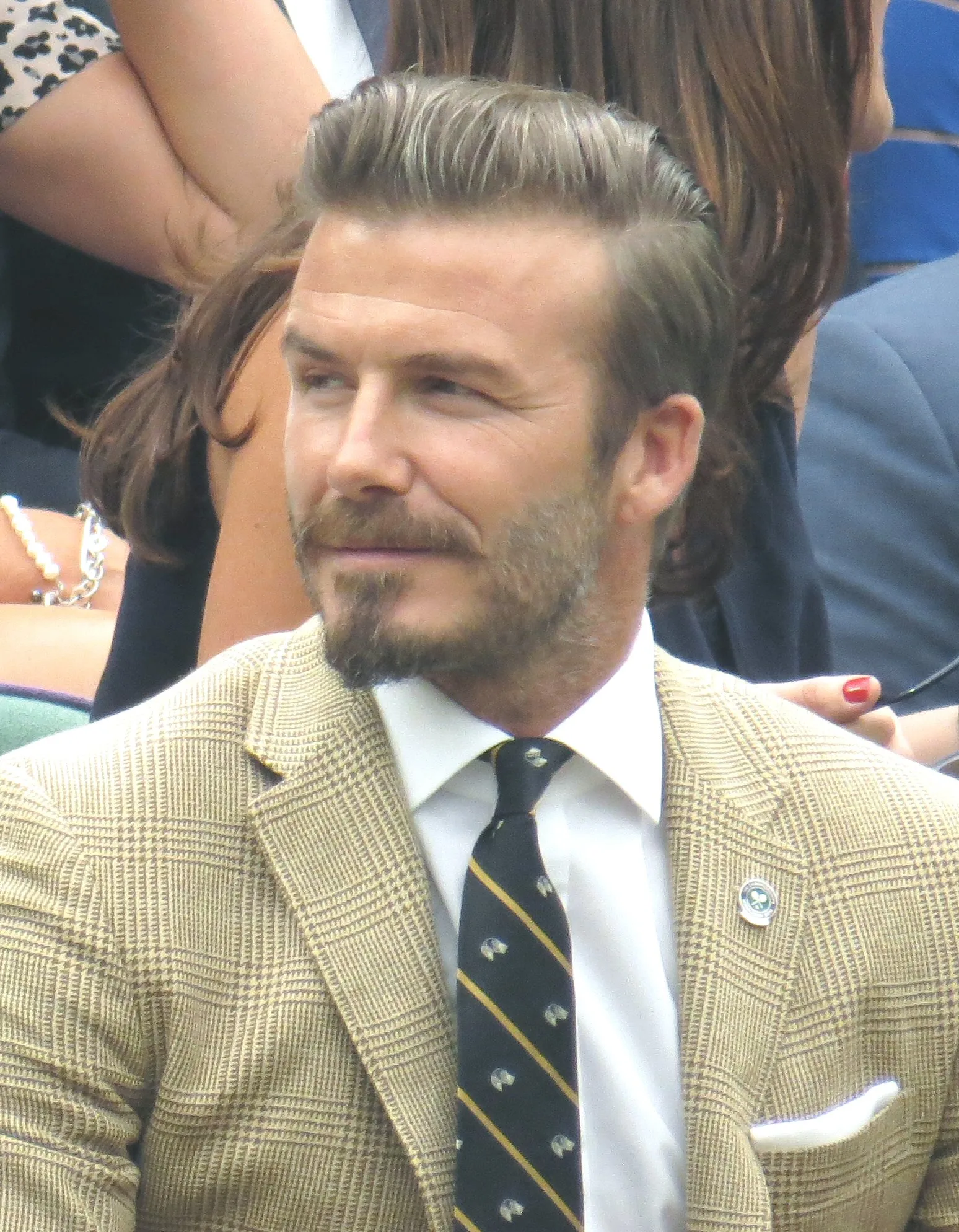 David Beckham in the Wimbledon royal box in 2014, with a longer voluminous top swept back over short sides.