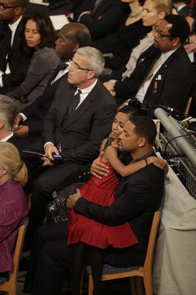 Will Smith seated at a 2009 Nobel Peace Prize event, shown in profile with a close-cropped haircut.
