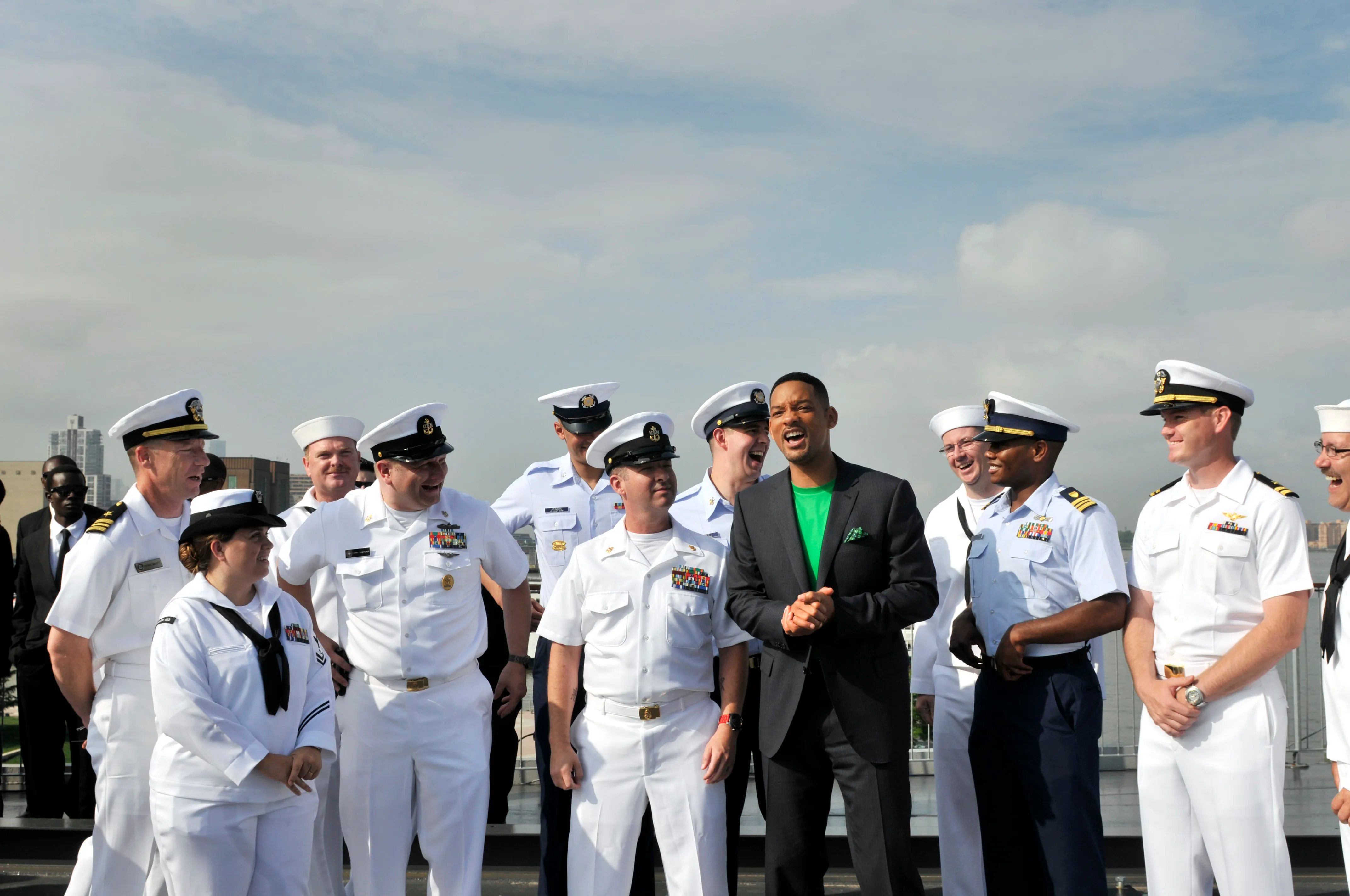 Will Smith aboard the Intrepid during Fleet Week New York in 2012, wearing a short close-cropped haircut beside sailors.