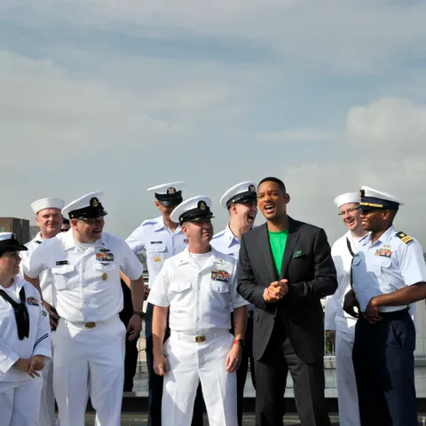 Will Smith aboard the Intrepid during Fleet Week New York in 2012, wearing a short close-cropped haircut beside sailors.